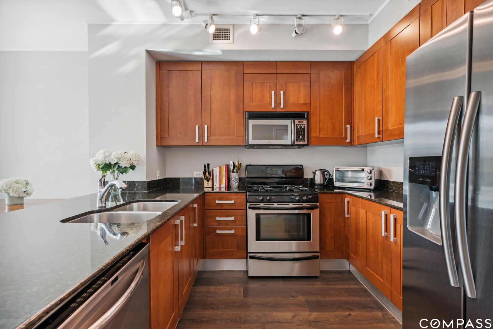 744 North Clark Street, Unit 704 Chicago, IL 60654 - Photo 6 of 12 a kitchen with stainless steel appliances granite countertop a stove a sink and a microwave