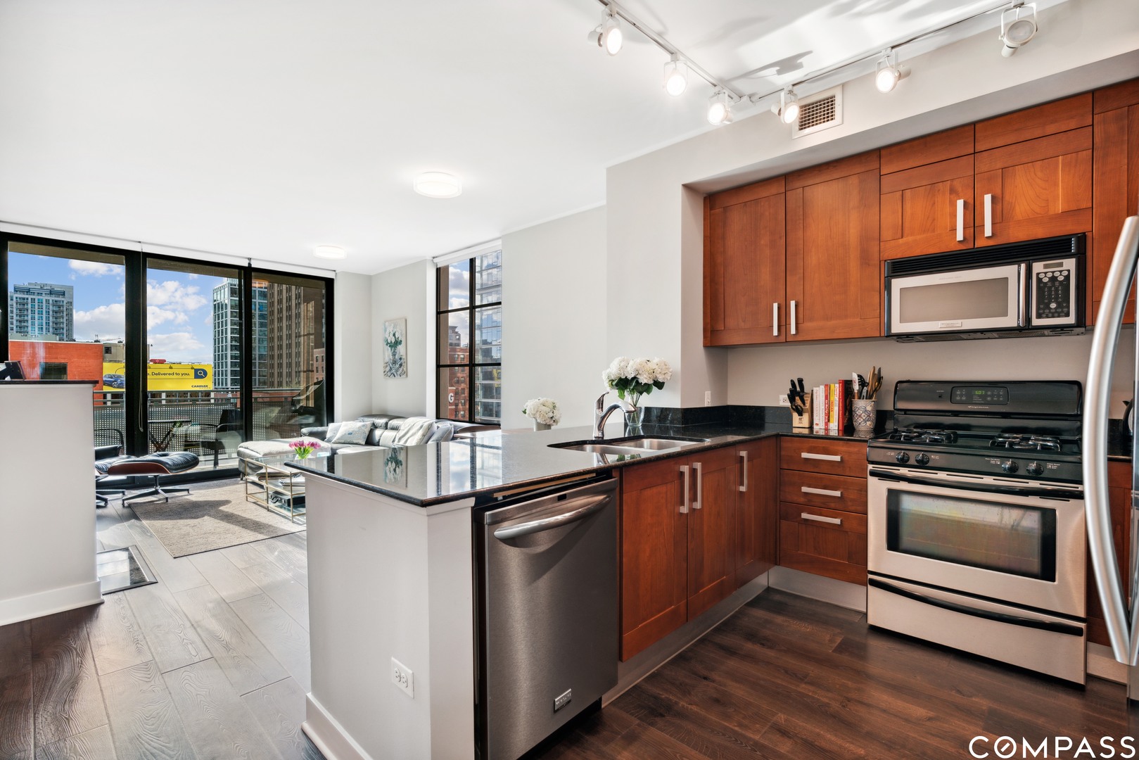 744 North Clark Street, Unit 704 Chicago, IL 60654 - Photo 7 of 12 a kitchen with stainless steel appliances granite countertop a stove a sink and a microwave