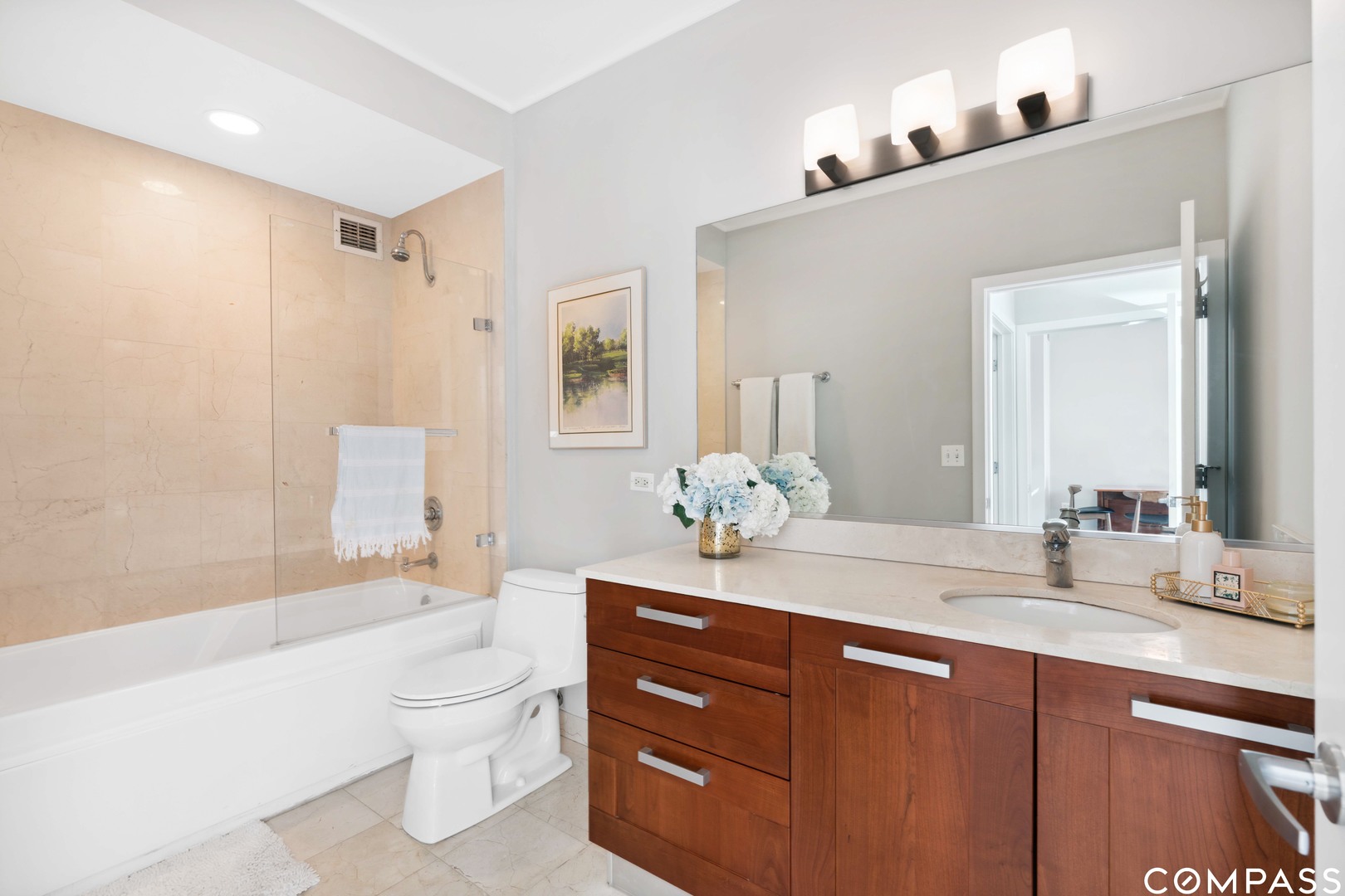 744 North Clark Street, Unit 704 Chicago, IL 60654 - Photo 9 of 12 a bathroom with a granite countertop sink a toilet a large mirror and shower