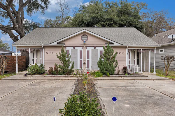 a front view of a house with a yard and potted plants