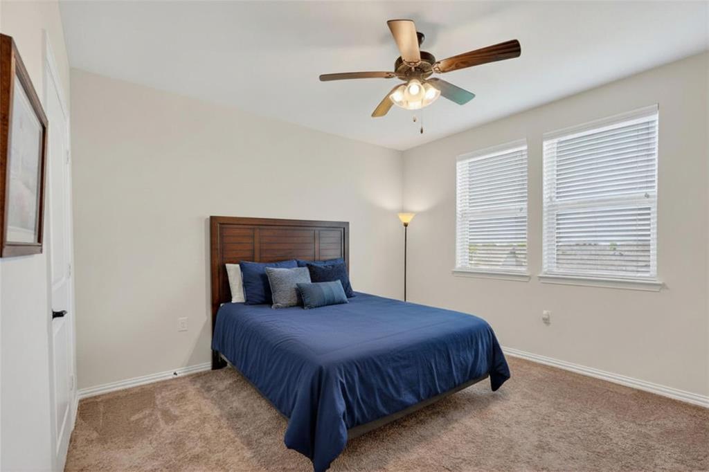 651 Watters Road, Unit 5305 Allen, TX 75013 - Photo 19 of 40 a bedroom with a large bed and a ceiling fan