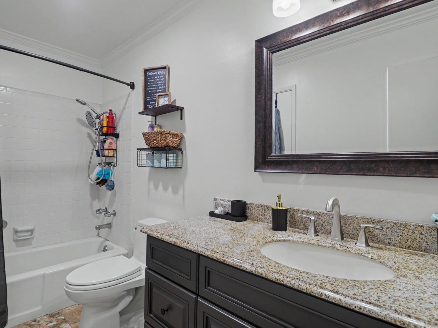 1310 Primavera Street, Unit 109 Salinas, CA 93901 - Photo 21 of 37 a bathroom with a granite countertop sink mirror vanity and toilet