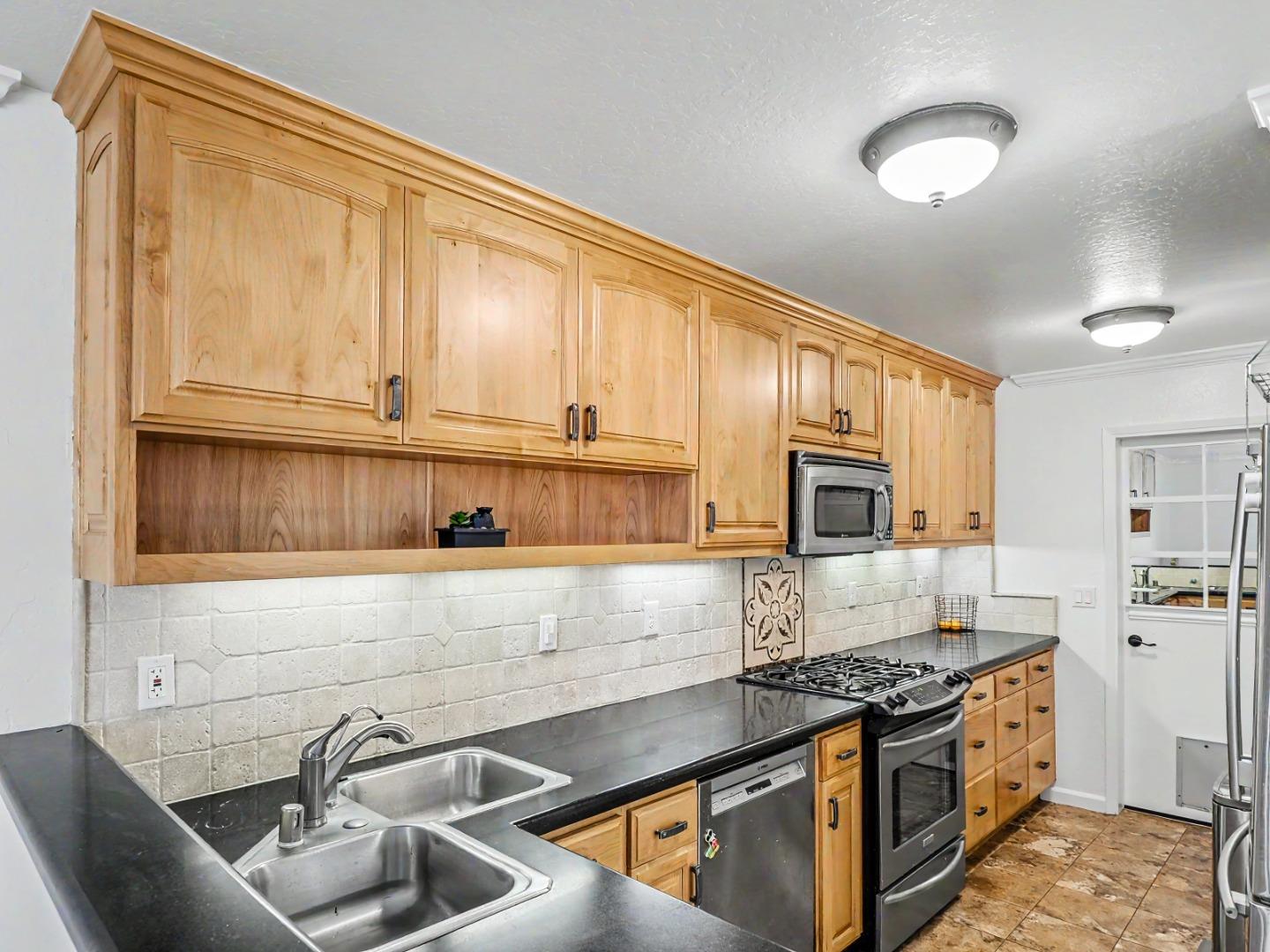 1310 Primavera Street, Unit 109 Salinas, CA 93901 - Photo 4 of 37 a kitchen with stainless steel appliances granite countertop a sink stove and cabinets