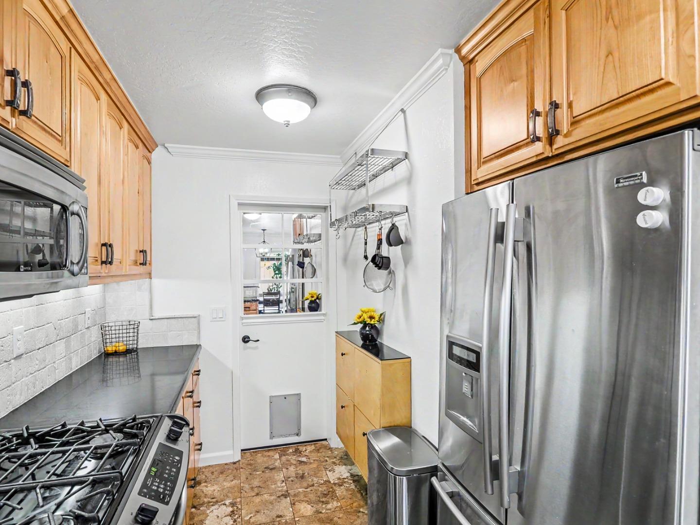 1310 Primavera Street, Unit 109 Salinas, CA 93901 - Photo 5 of 37 a kitchen with stainless steel appliances granite countertop a refrigerator and a stove