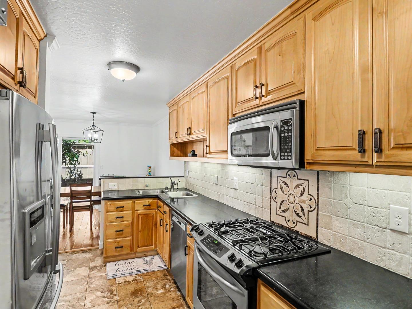 1310 Primavera Street, Unit 109 Salinas, CA 93901 - Photo 6 of 37 a kitchen with stainless steel appliances granite countertop a stove a sink and a microwave