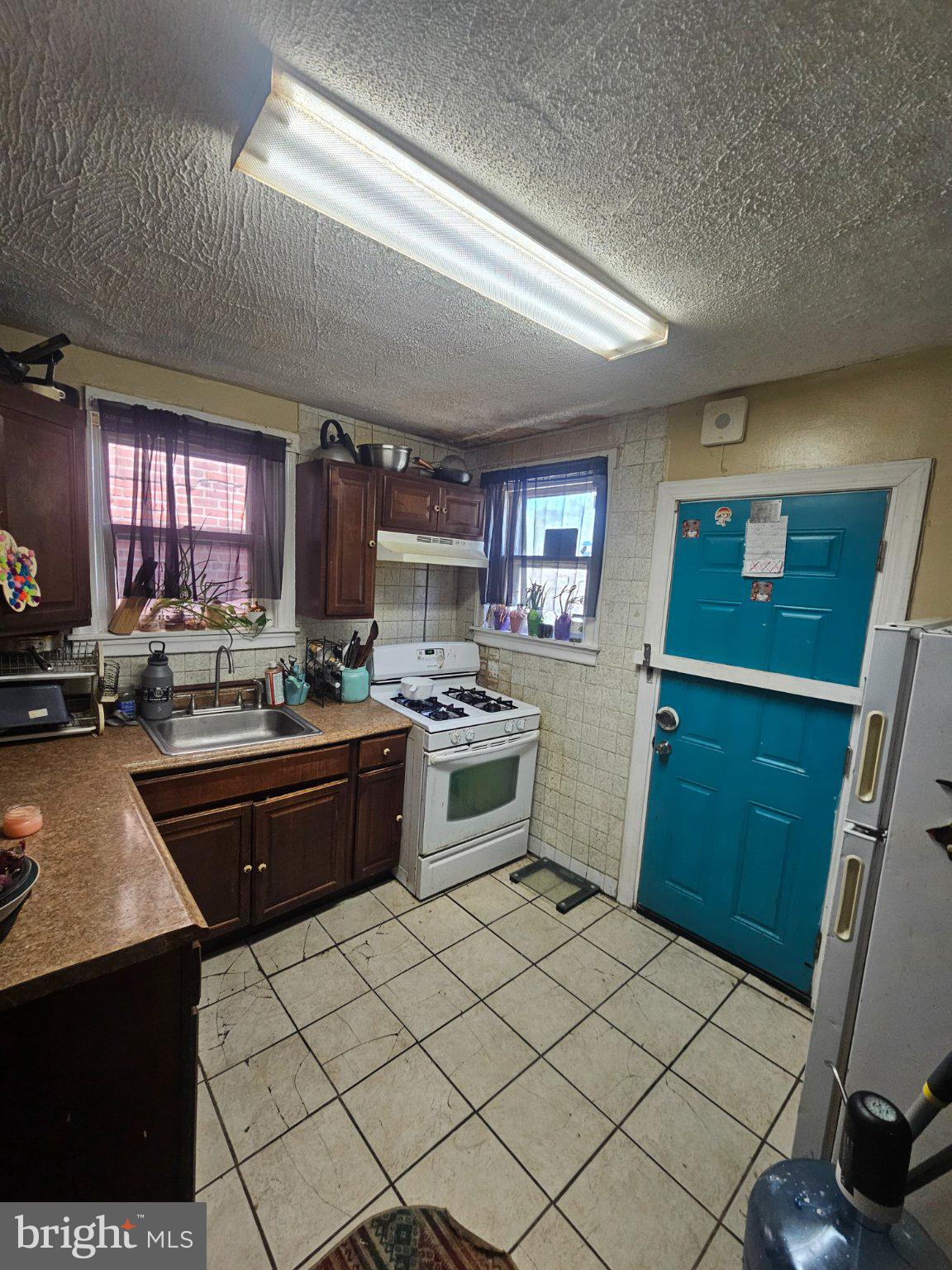 6913 Rodney Street Philadelphia, PA 19138 - Photo 7 of 17 a kitchen with a sink a stove cabinets and a window