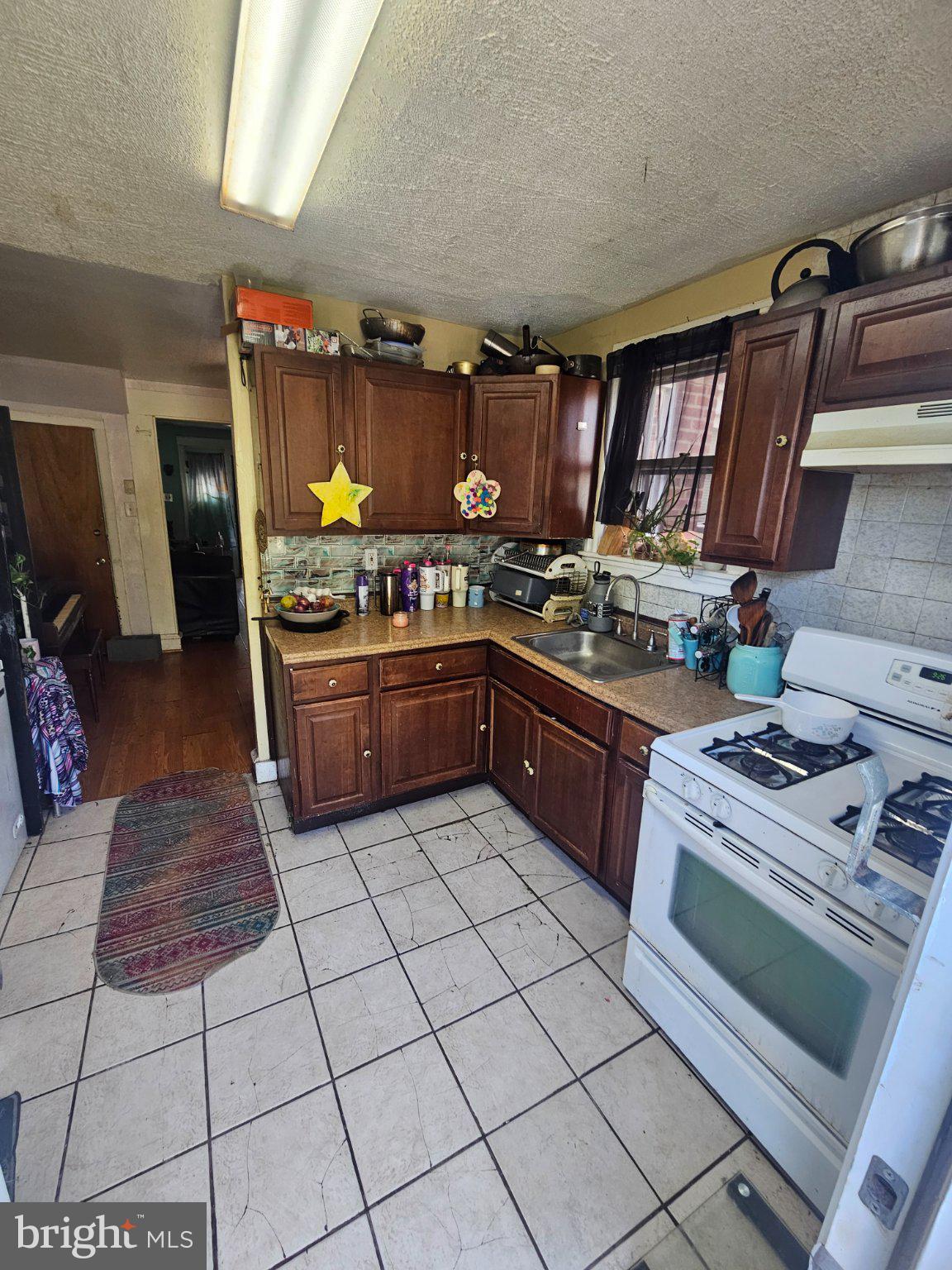 6913 Rodney Street Philadelphia, PA 19138 - Photo 8 of 17 a kitchen with stainless steel appliances granite countertop a stove a sink dishwasher and cabinets