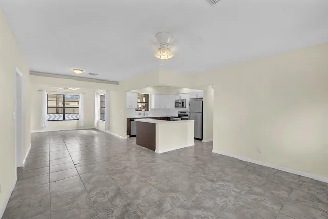 a view of kitchen with furniture and refrigerator