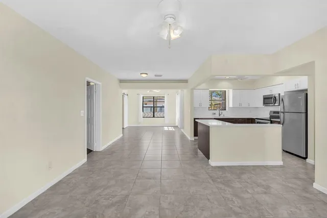 a large kitchen with kitchen island a sink stainless steel appliances and cabinets