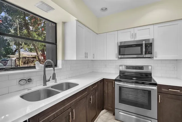 a kitchen with stainless steel appliances granite countertop a refrigerator and a stove top oven