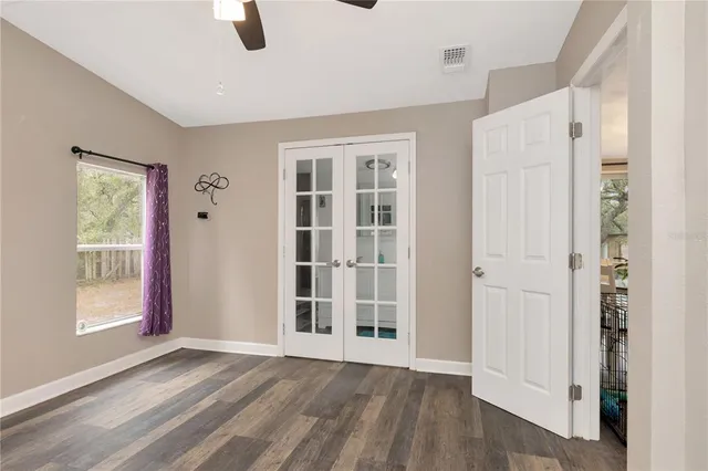 a view of an empty room with window and wooden floor