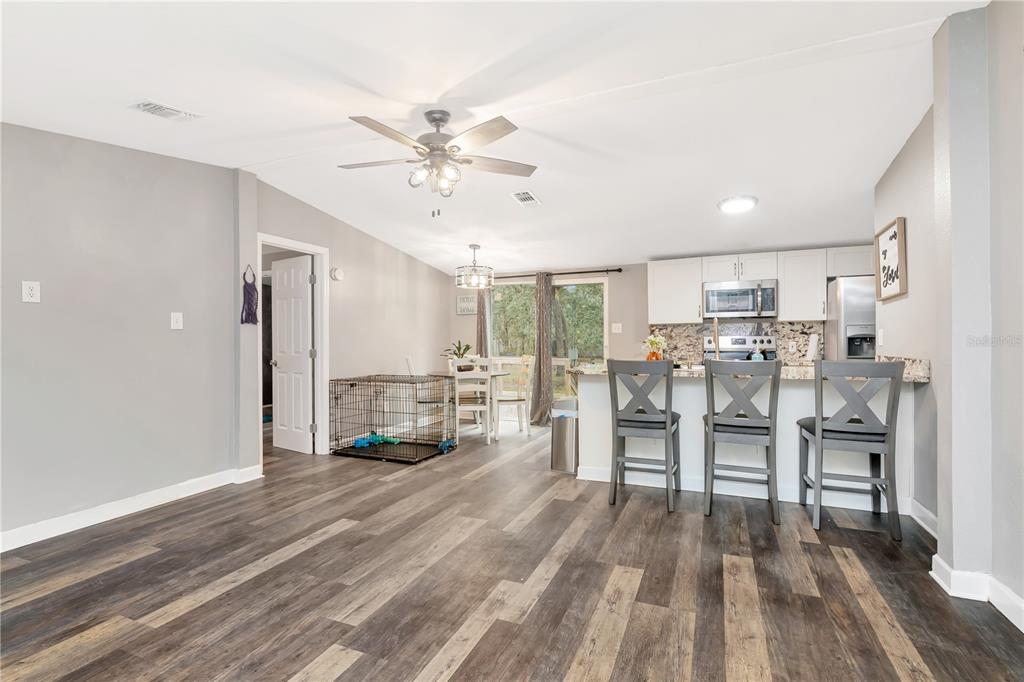 16323 Alliance Lane Spring Hill, FL 34610 - Photo 3 of 34 a living room with wooden floor furniture and a kitchen view