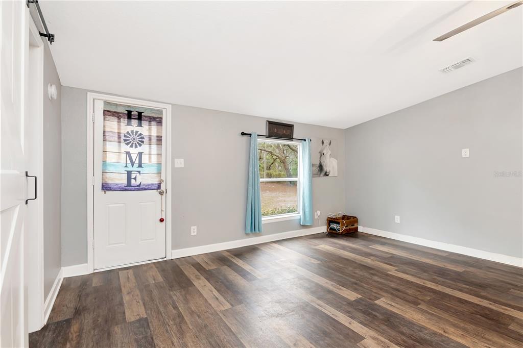 16323 Alliance Lane Spring Hill, FL 34610 - Photo 5 of 34 an empty room with wooden floor and windows