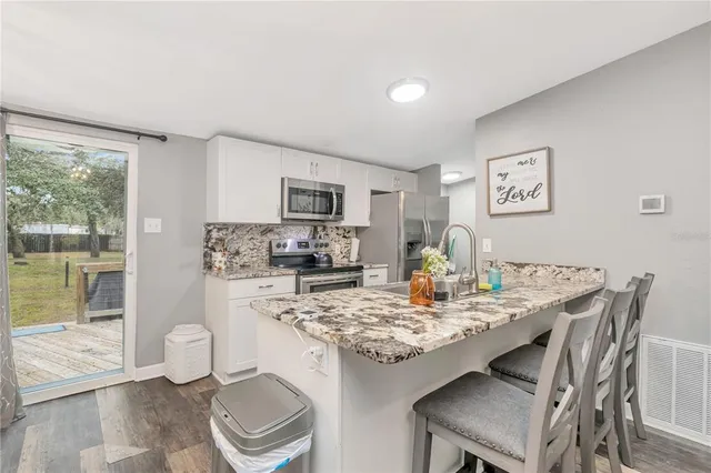 a view of a dining room with furniture a chandelier and wooden floor