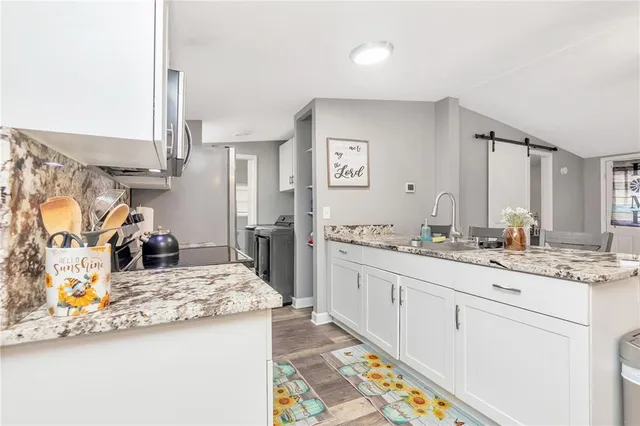 a kitchen with stainless steel appliances granite countertop a sink stove and cabinets