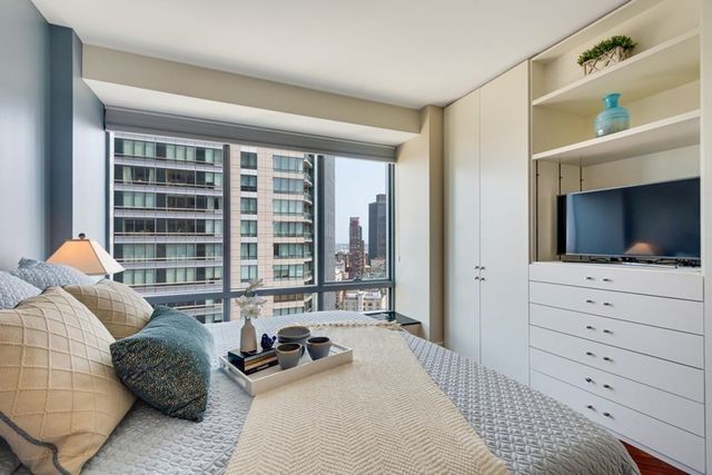 a bedroom with a bed a window and dresser