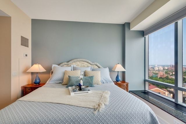 a bedroom with a bed and a large window