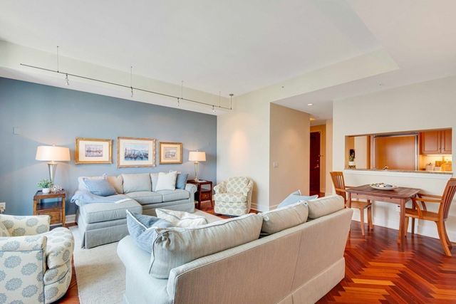 a living room with furniture wooden floor and a dining table