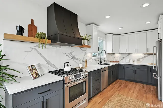 a kitchen with stainless steel appliances a sink stove and cabinets