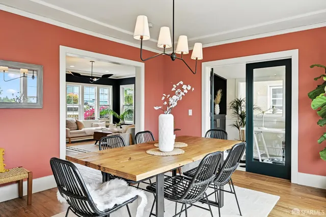 a dining room with furniture a chandelier and wooden floor
