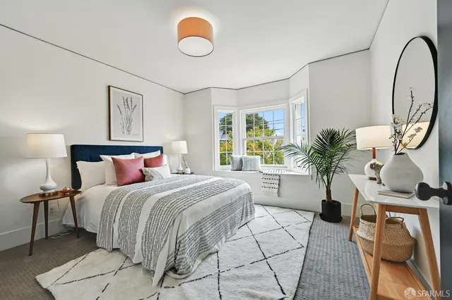 a bedroom with a large bed and a potted plant