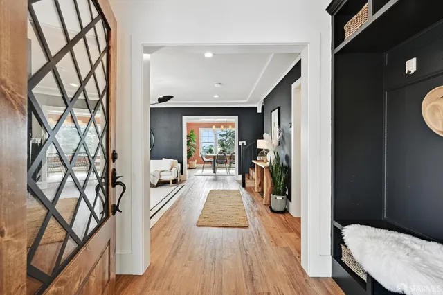 a view of a hallway with wooden floor and furniture