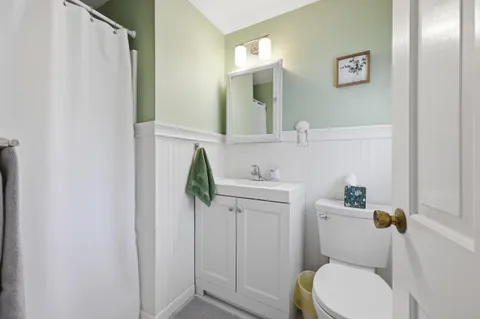a bathroom with a toilet sink and mirror