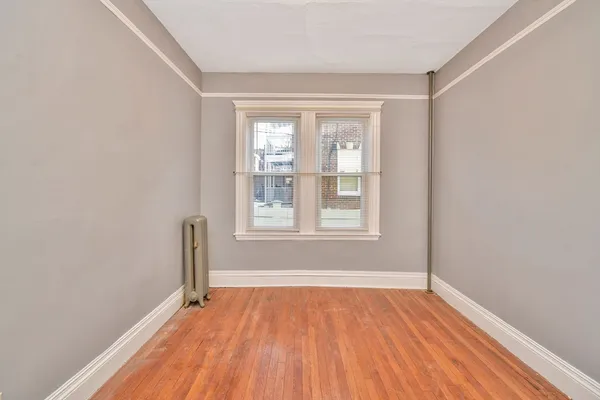a view of a room with wooden floor and a window