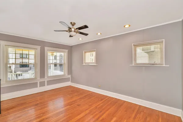 a view of an empty room with a window and wooden floor