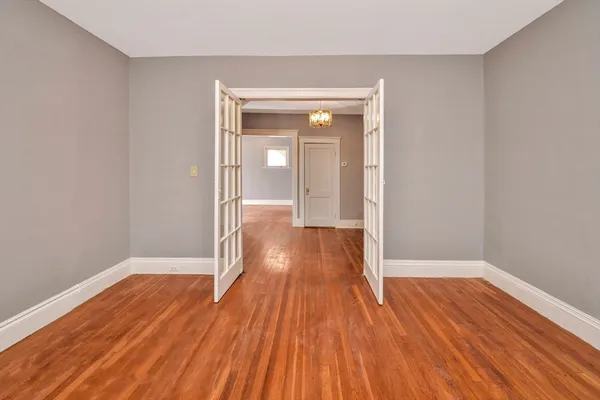 a hallway with wooden floor and chandelier