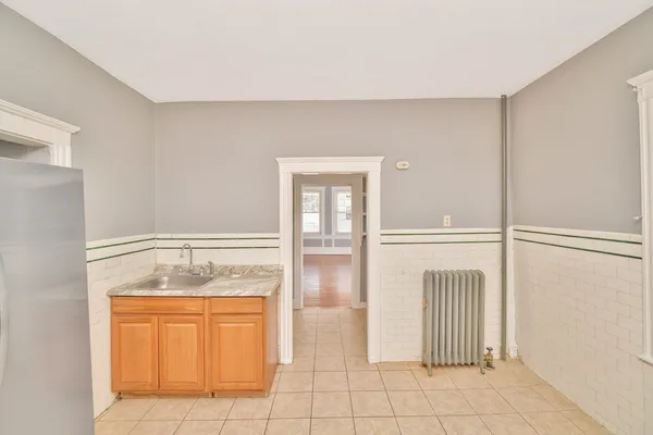 a view of empty room with cabinet and mirrors