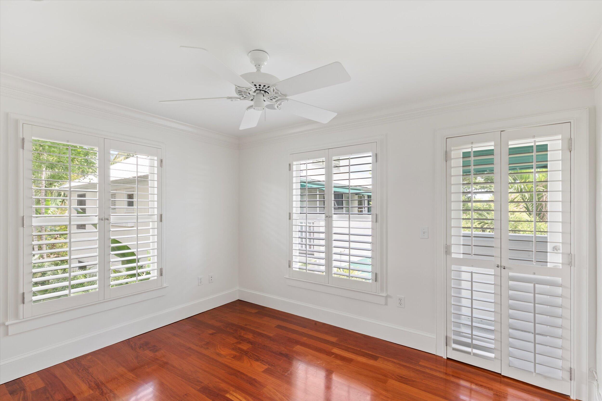 413 Emma Street, Unit A Key West, FL 33040 - Photo 38 of 64 a view of an empty room with a window and wooden floor
