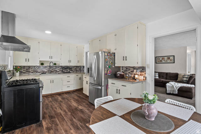 88 East C Street Springville, UT 84663 - Photo 7 of 32 Kitchen featuring extensive white cabinetry, a mosaic tile backsplash, stainless steel appliances, and wood-finish flooring