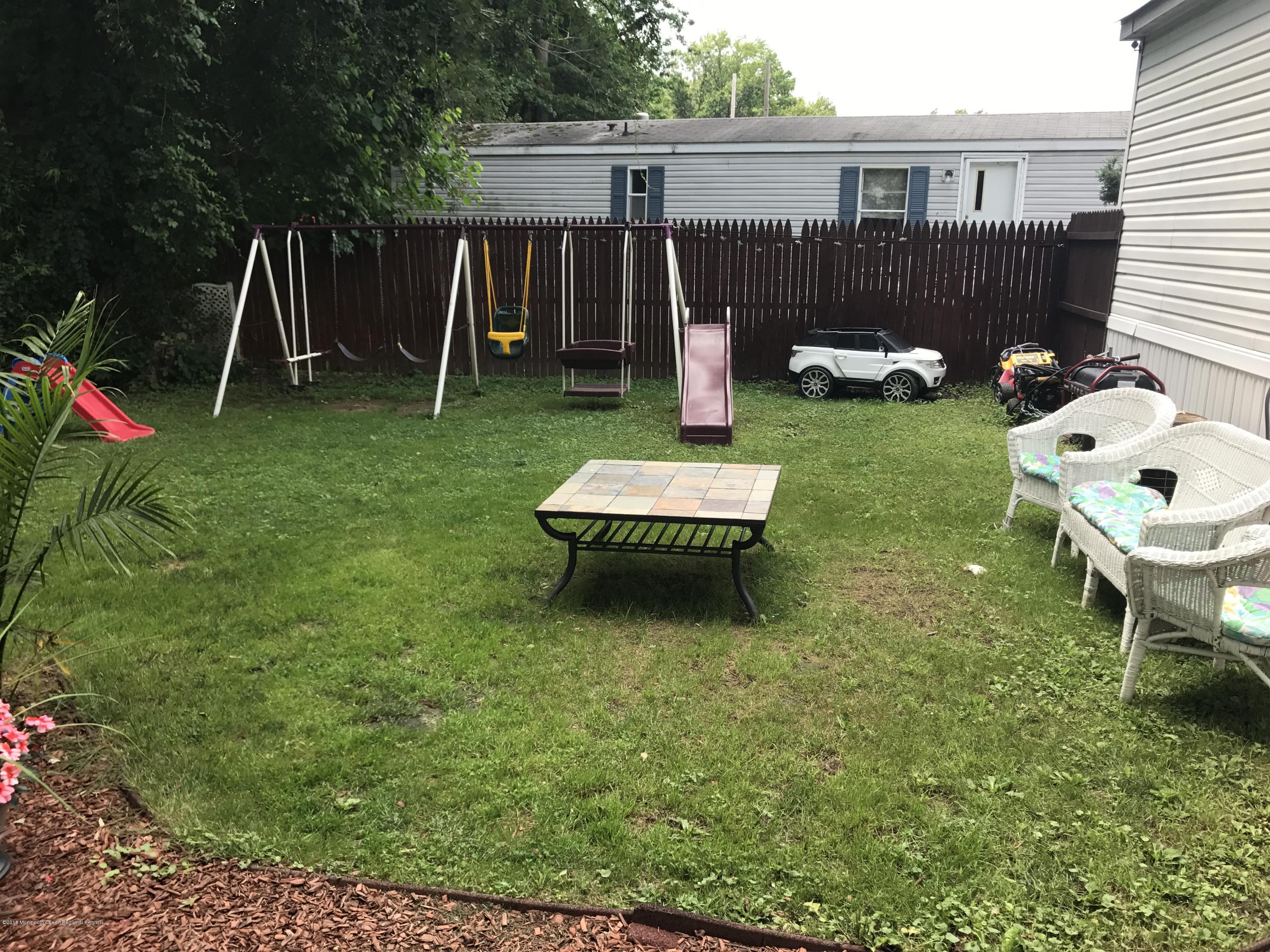 1272 Highway 36, Unit 39 Hazlet, NJ 07730 - Photo 12 of 13 a backyard of a house with table and chairs