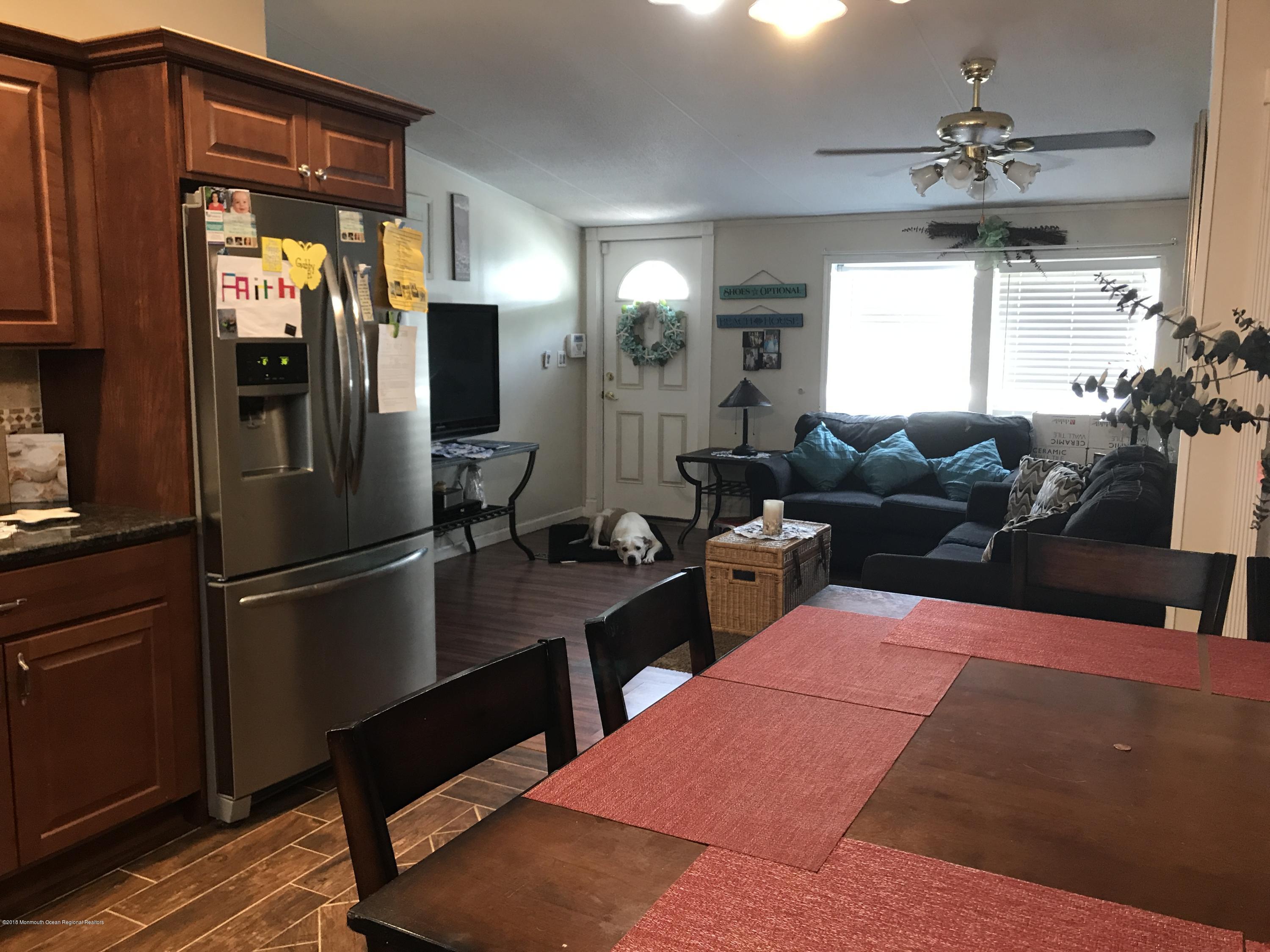 1272 Highway 36, Unit 39 Hazlet, NJ 07730 - Photo 4 of 13 a kitchen with stainless steel appliances kitchen island granite countertop a refrigerator a stove and a dining table with wooden floor