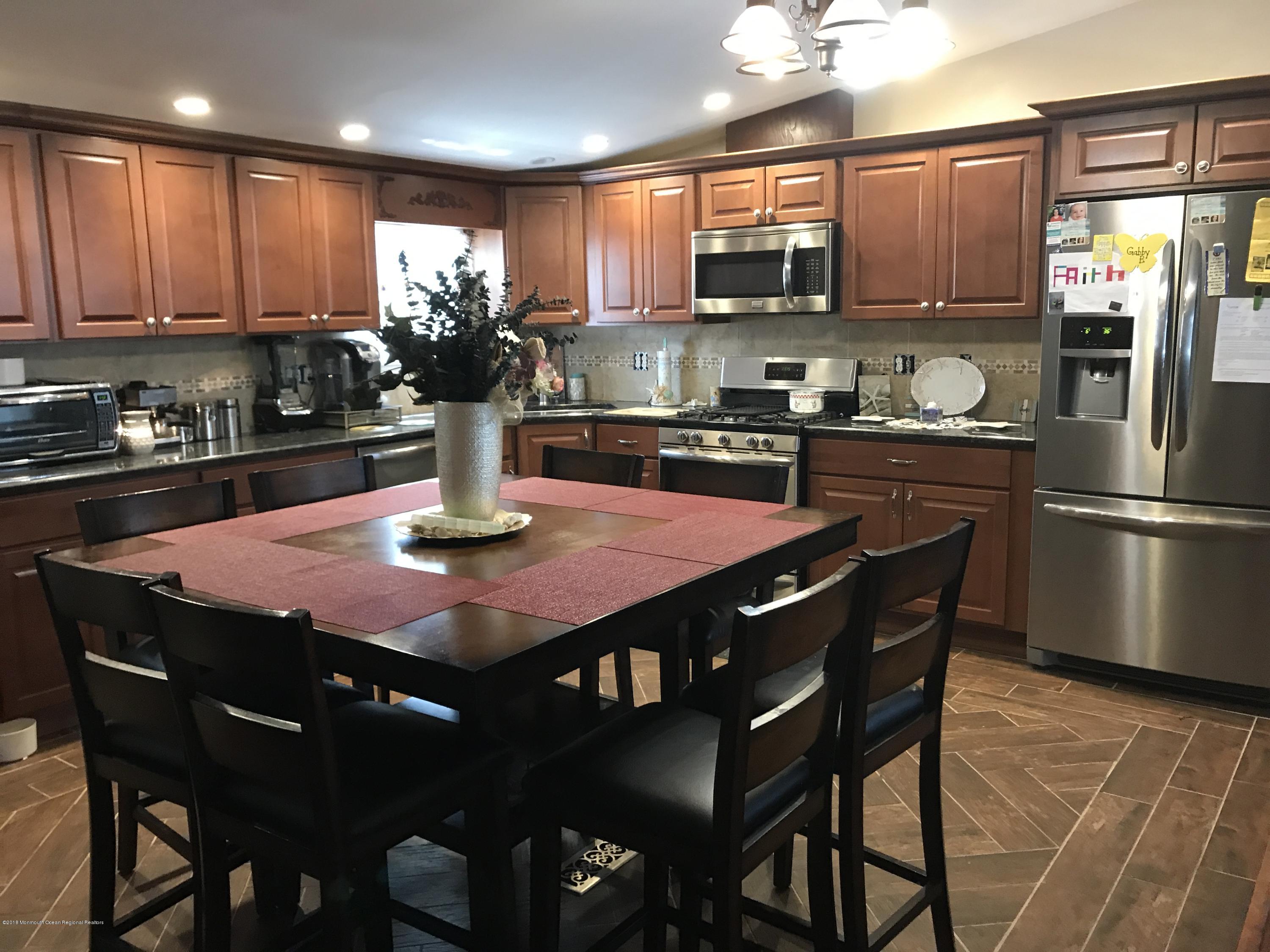 1272 Highway 36, Unit 39 Hazlet, NJ 07730 - Photo 5 of 13 a kitchen with stainless steel appliances granite countertop a sink a stove a table and chairs