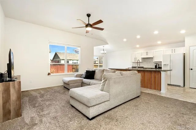 a living room with furniture and kitchen view