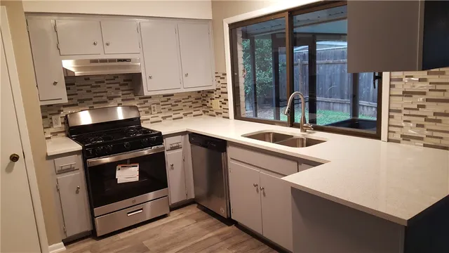 a kitchen with granite countertop a stove and a sink