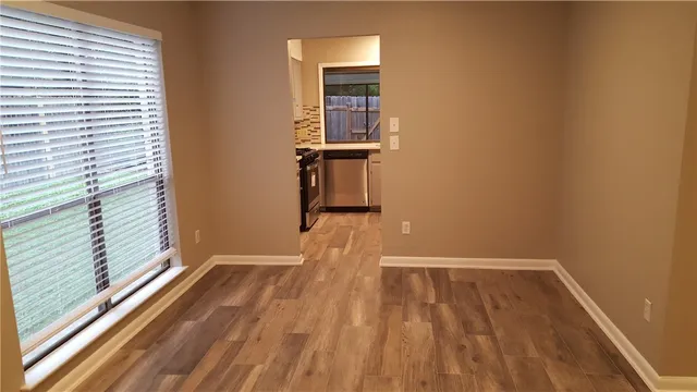 a view of a room with wooden floor and small window