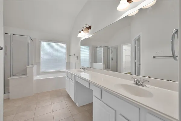 a bathroom with a tub a sink and mirror