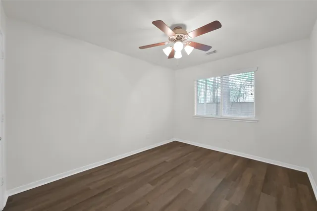 a view of a big room with wooden floor and windows