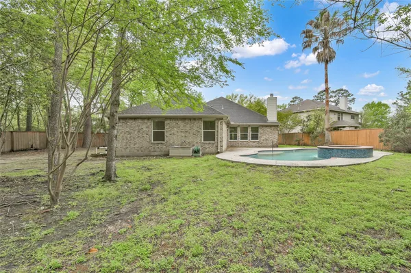 a view of a house with a backyard and a tree