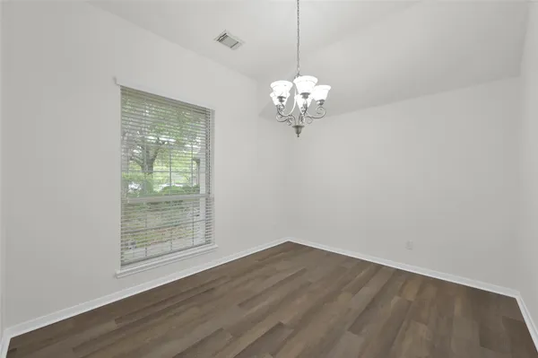 a view of a room with wooden floor and chandelier