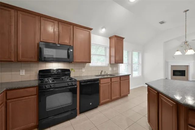 a kitchen with stainless steel appliances granite countertop wooden cabinets stove top oven and sink