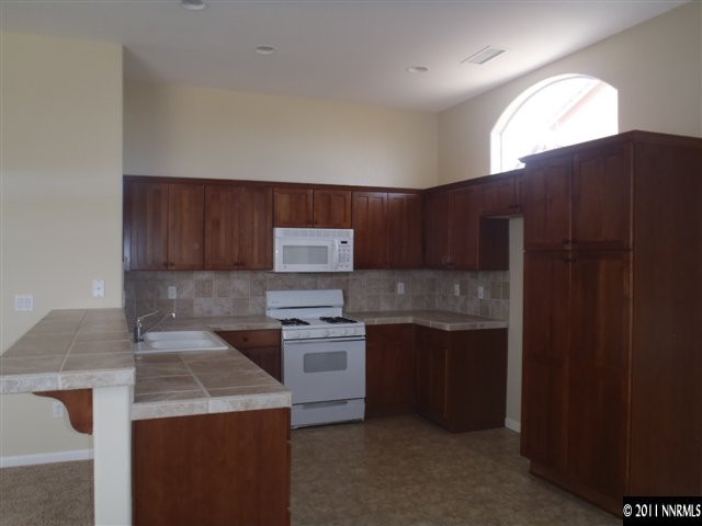 1547 Orca Way Reno, NV 89506 - Photo 7 of 13 a kitchen with a stove and a refrigerator