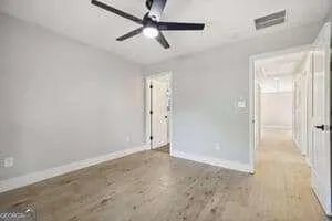an empty room with closet and a ceiling fan
