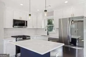 a kitchen with a refrigerator a sink and a stove top oven