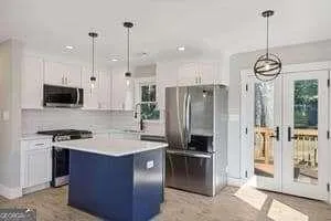 a kitchen with stainless steel appliances granite countertop a refrigerator a stove a sink and a chandelier