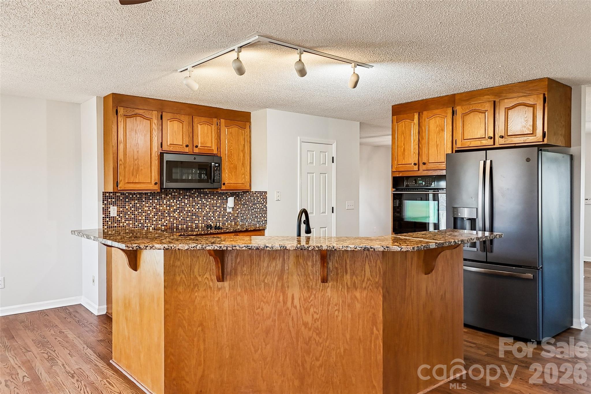 2034 New Prospect Church Road Shelby, NC 28150 - Photo 12 of 48 a kitchen with stainless steel appliances granite countertop a refrigerator a stove and a sink with wooden floor