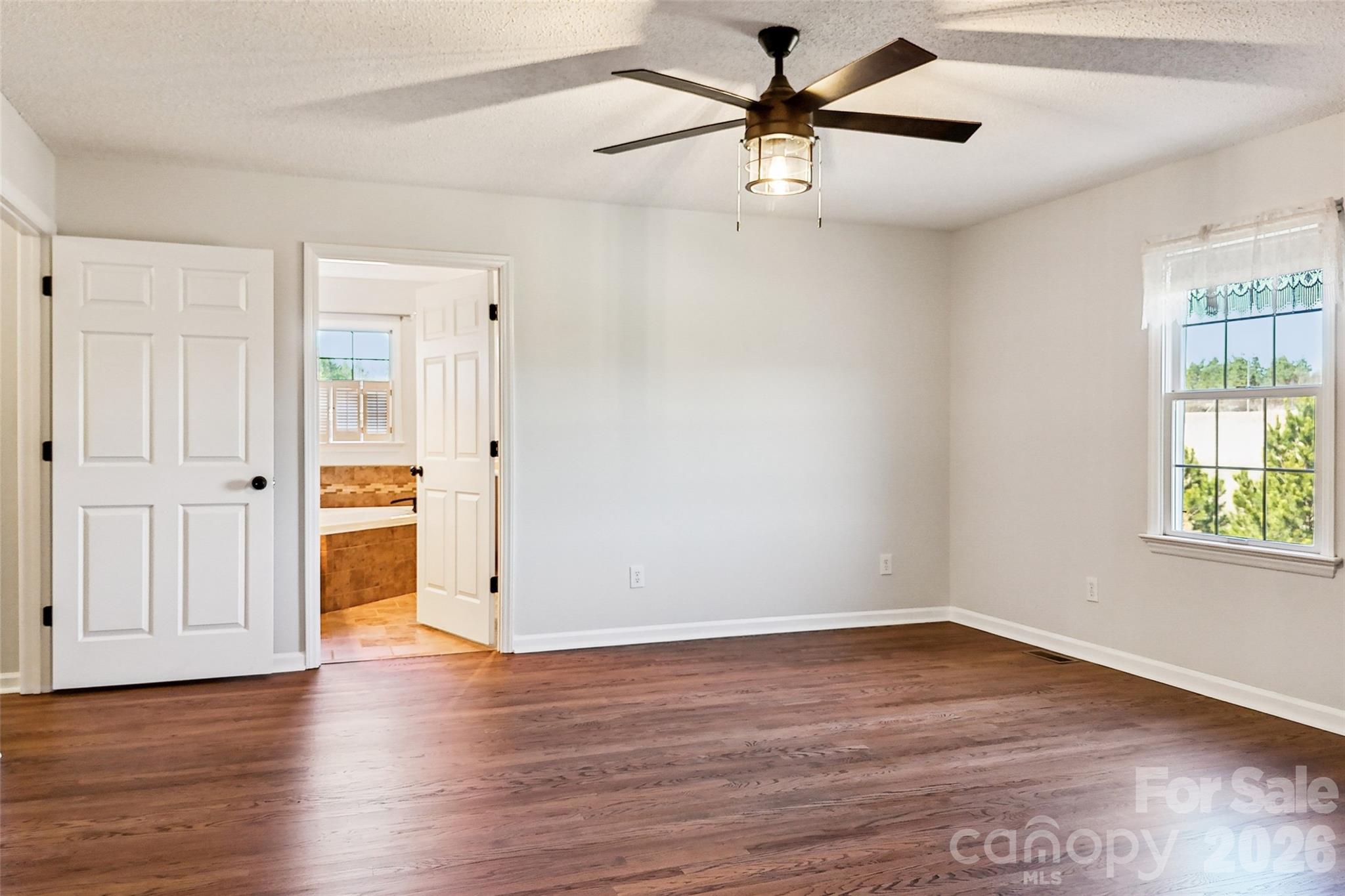 2034 New Prospect Church Road Shelby, NC 28150 - Photo 18 of 48 an empty room with wooden floor chandelier fan and windows